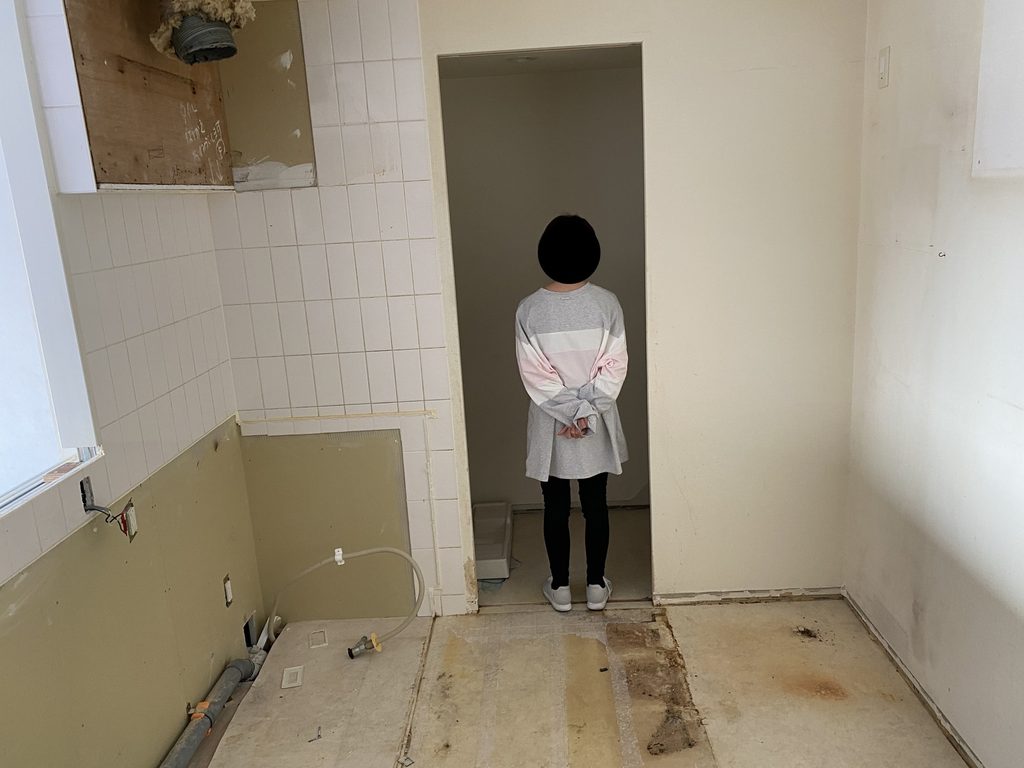 既存キッチン撤去後に床や壁、配管が露出した工事中のキッチン